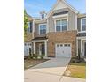 Charming two-story townhome with brick accents, a garage, and a welcoming entrance, showcasing its attractive facade at 214 George Pine Way, Knightdale, NC 27545