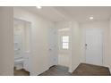 Hallway with wood floors leading to a bathroom and bedroom with natural light and neutral colors at 228 Palomino Way, Clayton, NC 27520