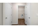 A hallway with wood floors shows doors to storage and a utility room, offering convenient access at 228 Palomino Way, Clayton, NC 27520