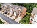 Brick townhomes boast manicured lawns, attached garages, and convenient street parking at 2740 Laurelcherry St, Raleigh, NC 27612