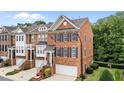 Elegant brick townhome with manicured landscaping, blue shutters, and a convenient attached garage at 2740 Laurelcherry St, Raleigh, NC 27612