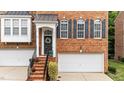 Beautiful brick townhome featuring an inviting front door, lovely wreath, and an attached garage at 2740 Laurelcherry St, Raleigh, NC 27612