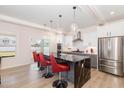 Bright kitchen features stainless steel appliances, modern cabinetry, and a large island with marble accents and pendant lighting at 311 Horseshoe Pl, Angier, NC 27501