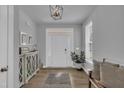 Bright foyer with hardwood floors, modern light fixture, and a welcoming white door at 325 Buckhorn Branch Park, Clayton, NC 27520