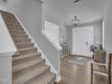 Open foyer featuring staircase, hardwood floors, and white front door, creating a welcoming ambiance at 325 Buckhorn Branch Park, Clayton, NC 27520