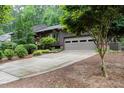 Exterior shot of home with a driveway leading to an attached garage; lush landscaping in the front yard at 3285 Edinburgh Dr, Sanford, NC 27332