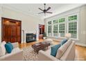 Bright living room featuring a fireplace, built-in shelving, hardwood floors, and large windows at 3728 Westbury Lake Dr, Raleigh, NC 27603
