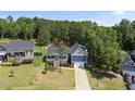 Two-story blue home with a well-maintained lawn and two-car garage, surrounded by lush trees at 374 Heart Pine Dr, Wendell, NC 27591