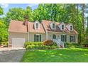 Charming single-Gathering home with lush green lawn, mature landscaping, and dormer windows at 3806 Lochnora Pkwy, Durham, NC 27705