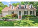 Charming single-Gathering home with lush green lawn, mature landscaping, and dormer windows at 3806 Lochnora Pkwy, Durham, NC 27705