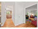 Inviting hallway with hardwood floors leading to a playroom and kitchen with wood cabinetry at 3806 Lochnora Pkwy, Durham, NC 27705