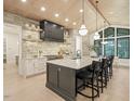 The kitchen features a large island, stone accent wall, modern appliances, and stylish pendant lighting at 4 Rainforest Pl, Apex, NC 27523