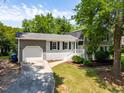 The home's exterior showcases a blend of gray siding, white brick accents, and a well-maintained front yard at 4001 Pin Oak Rd, Raleigh, NC 27604