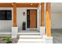 Inviting front entryway with wood door, wood columns, painted brick base and steps and nice landscaping at 411 Bon Air Ave, Durham, NC 27704
