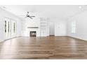 Bright living room featuring hardwood floors, a white brick fireplace, built-in shelving, and french doors at 50 Farmstead Ct, Wendell, NC 27591