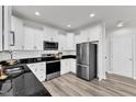 Modern kitchen featuring white cabinets, sleek black countertops, and stainless steel appliances for a chef's delight at 520 Oak Holly Ln, Zebulon, NC 27597