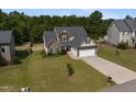 Inviting two-story home featuring a well-manicured lawn and attached two-car garage at 550 Spring Flowers Dr, Cameron, NC 28326