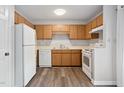 Functional kitchen showcasing wood cabinets, a white refrigerator, and standard white appliances at 5911 Westcreek Pl, Raleigh, NC 27606