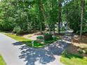 Landscaped front yard view of a quaint house nestled among mature trees in a lovely neighborhood at 608 Misty Isle Pl, Raleigh, NC 27615