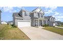 Charming home with a spacious driveway and attached garage with a lovely front porch at 645 Longstanton Ave, Zebulon, NC 27597