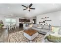 Open-concept living area with a modern ceiling fan, a gray sofa, and access to the kitchen at 645 Longstanton Ave, Zebulon, NC 27597