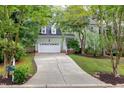 Two-story home with a long driveway leading up to a two-car garage at 709 Bonhurst Dr, Holly Springs, NC 27540
