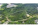Aerial view shows heavily wooded lot outlined in white with nearby community at 7104 Camp Branch Ln, Apex, NC 27502