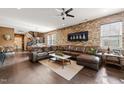 Spacious living area featuring a leather sectional sofa and a decorative brick accent wall at 744 Birch Arbor Cir, Raleigh, NC 27604