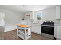 Bright kitchen with modern stainless steel appliances, white cabinets, and wood-look flooring at 1006 E Harnett St, Dunn, NC 28334