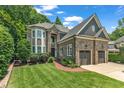 Charming stone home featuring a well-kept lawn and lovely landscaping at 104 Bellagio Dr, Apex, NC 27539