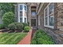Close-up of the stone front entrance with a walkway and lush landscaping at 104 Bellagio Dr, Apex, NC 27539
