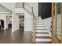 Bright foyer features white walls, staircase, paneled wall, and hardwood floors at 1141 Duke Farm Dr, Wake Forest, NC 27587