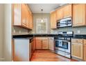 A gourmet kitchen with stainless appliances, wood cabinets, hardwood floors, and granite countertops; culinary dreams await at 127 Bobwhite Way, Mebane, NC 27302