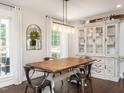Elegant dining room featuring hardwood floors, stylish lighting, and a charming china cabinet at 1625 Haystack Ln, Burlington, NC 27217