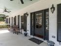 Inviting front porch featuring dark shutters, a black door and space for seating and potted plants at 1625 Haystack Ln, Burlington, NC 27217