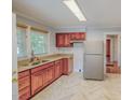Well-lit kitchen with stainless steel appliances, wood cabinets, and marble-patterned floors at 171 Magnolia Dr, Roxboro, NC 27573