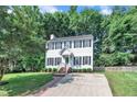 Traditional two-story home with a neatly landscaped yard, featuring classic architecture and symmetrical window placement at 1905 Indianwood Ct, Raleigh, NC 27604