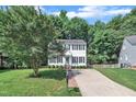 Two-story home featuring a well-kept lawn, mature trees, and a paved driveway leading to the front entrance at 1905 Indianwood Ct, Raleigh, NC 27604