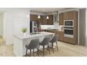 Modern kitchen with an island, stainless steel appliances, gray bar stools, and light hardwood floors at 2004 Kapalua Way # 189, Durham, NC 27703