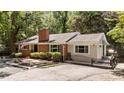 Attractive single-story home with brick facade, large windows, well-kept shrubbery, and black iron gate at 2005 Cole Mill Rd, Durham, NC 27712