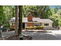 Single story brick home featuring mature trees, well-maintained landscaping, and a welcoming front entrance at 2005 Cole Mill Rd, Durham, NC 27712