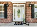 Elegant front door with decorative glass and a 'welcome' mat, flanked by black lanterns at 206 W Stoneybrook Ct, Benson, NC 27504