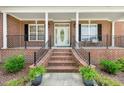 Inviting front porch with brick steps, decorative columns, and wrought iron railings at 206 W Stoneybrook Ct, Benson, NC 27504