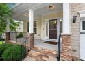Inviting front porch with stone accents, perfect for relaxing and enjoying the neighborhood views at 210 Strolling Way, Durham, NC 27707