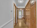 Hallway with hardwood floors, wooden doors, and ample closet space for storage at 2204 Basil Drive, Raleigh, NC 27612