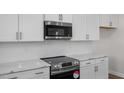Well-appointed kitchen featuring stainless steel appliances, white cabinets, and sleek countertops at 267 Old Fashioned Way, Lillington, NC 27546
