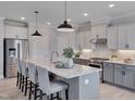 Modern eat-in kitchen with stainless steel appliances, gray cabinets, and a large center island at 3020 High Plains Dr, Fuquay Varina, NC 27526