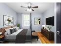 Well-staged main bedroom with hardwood floors, a padded headboard and bench, and a ceiling fan at 307 W Austin St, Mebane, NC 27302