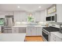 Updated kitchen with white cabinetry, stainless steel appliances, and sleek countertops at 4021 Converse Dr, Raleigh, NC 27609
