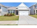 Attractive exterior featuring a two-car garage, landscaped front yard, and a mix of brick and siding elements at 427 Bluffberry Way, Hillsborough, NC 27278